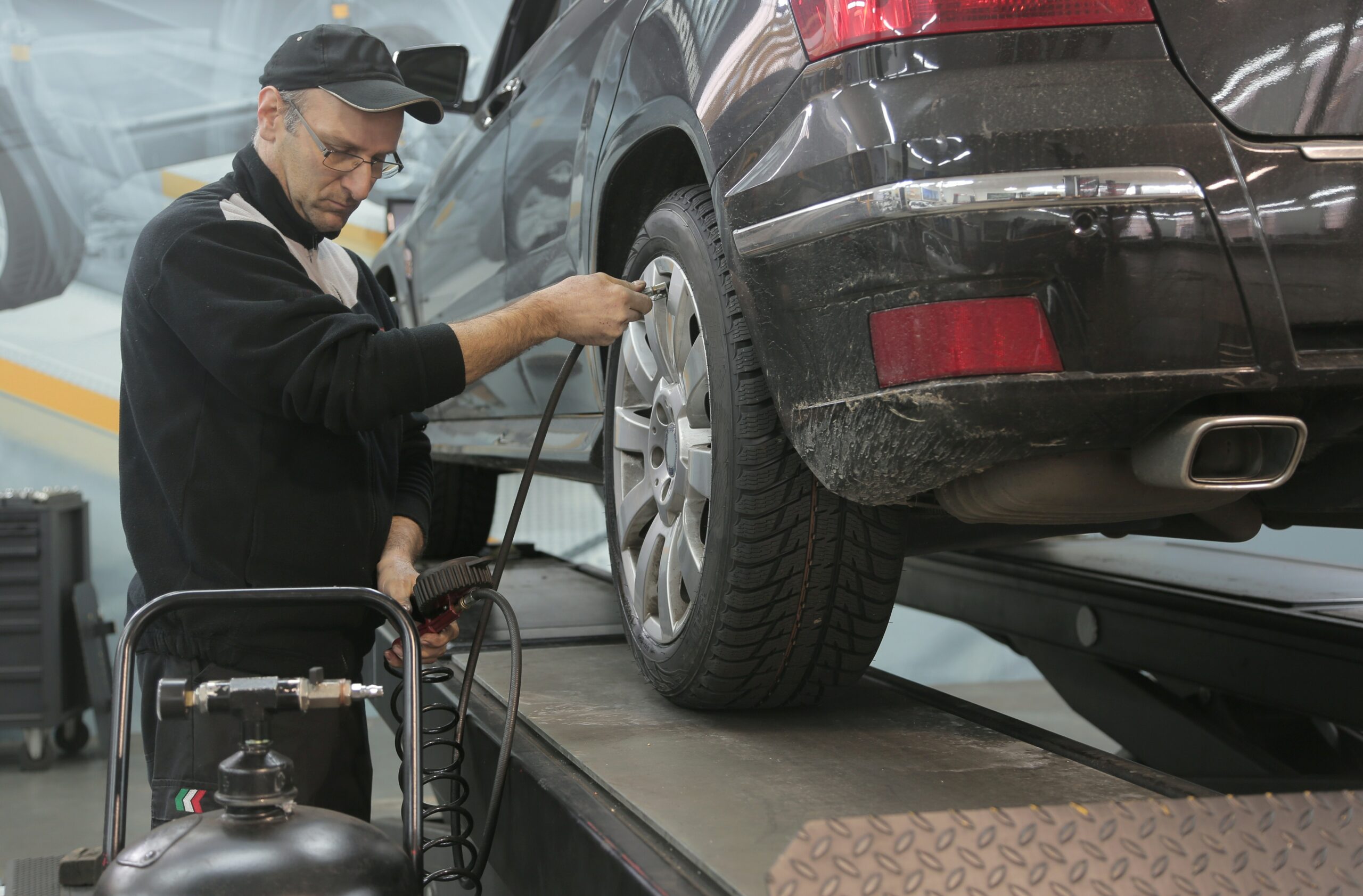 Un homme change un pneu dans un centre de montage agréé. L'importance de changer les pneus.