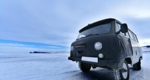 Pneu hiver ou été ? Une camionnette noire est sur une route enneigée