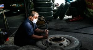 Comment est fabriqué un pneu ? Usine de fabrication de ce type de produits. Un homme finit un pneu