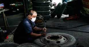 Comment est fabriqué un pneu ? Usine de fabrication de ce type de produits. Un homme finit un pneu