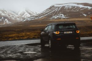 Quel type de pneu choisir ? Véhicule noir garé dans une montagne. Le paysage est neigé.
