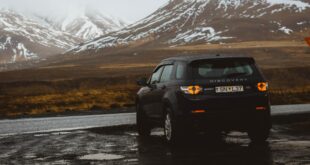 Quel type de pneu choisir ? Véhicule noir garé dans une montagne. Le paysage est neigé.