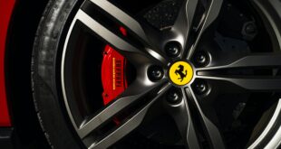 Comment nettoyer des jantes alu. Une voiture rouge avec un pneu monté. La jante est brillante