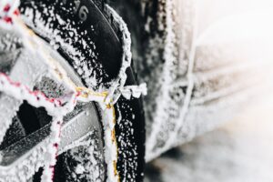 Une voiture avec des chaînes à neige métalliques montées.