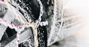 Une voiture avec des chaînes à neige métalliques montées.