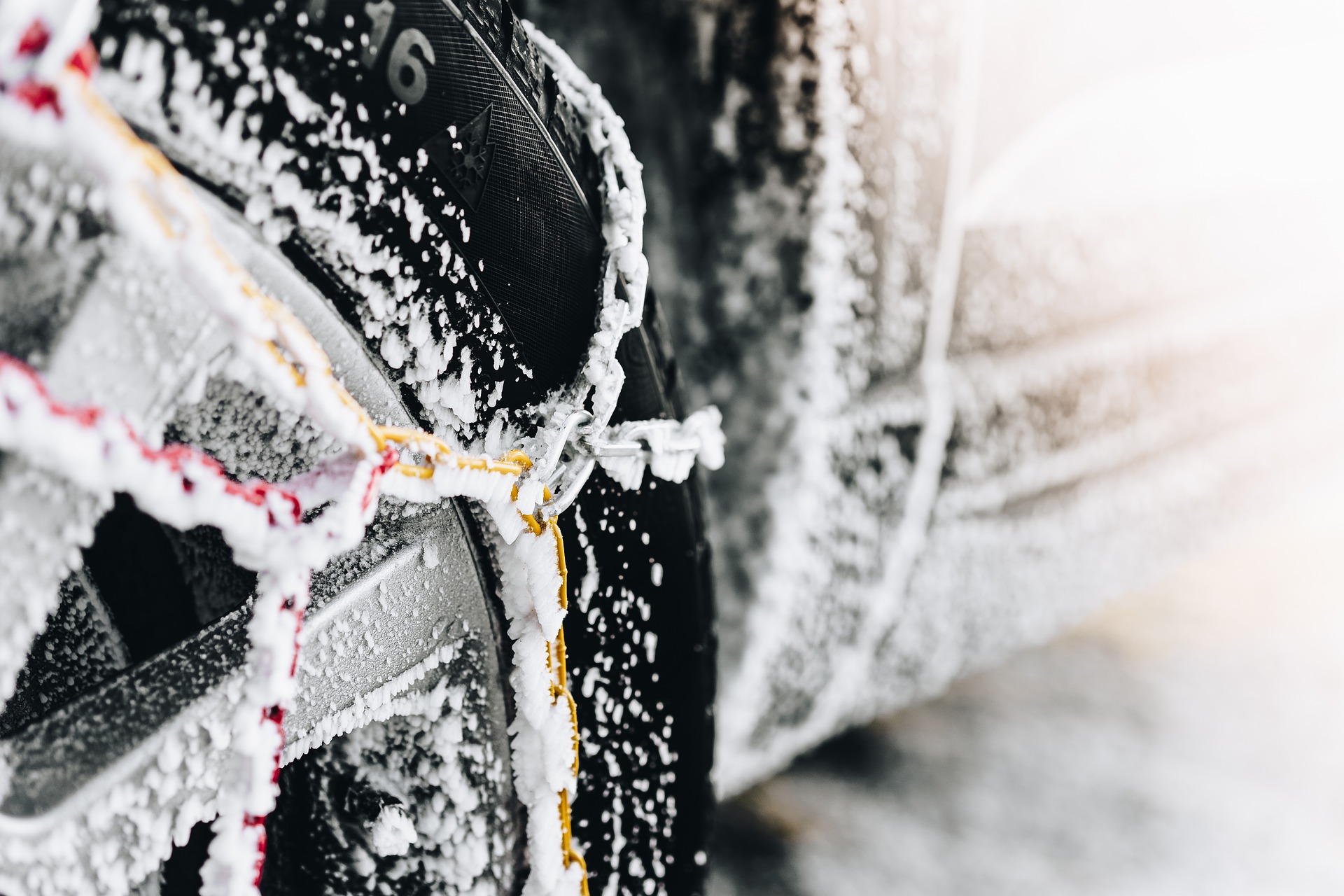 Une voiture avec des chaînes à neige métalliques montées.