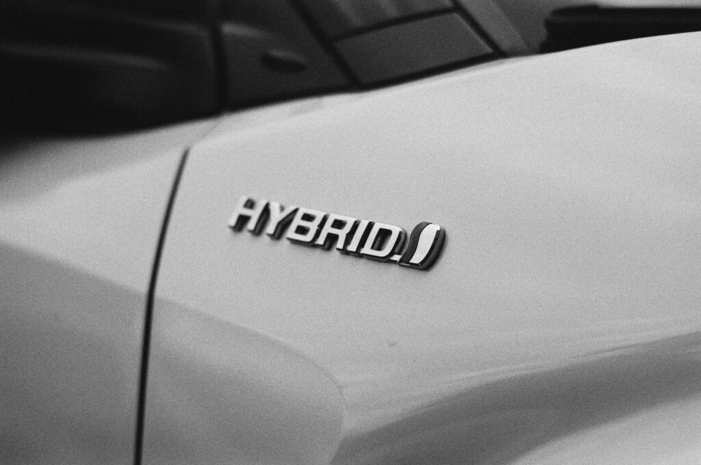 Une voiture blanche avec le texte "hybrid". Voiture hybride ou électrique