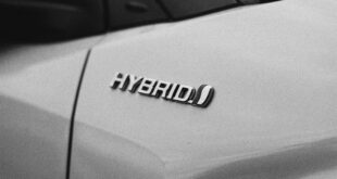 Une voiture blanche avec le texte "hybrid". Voiture hybride ou électrique